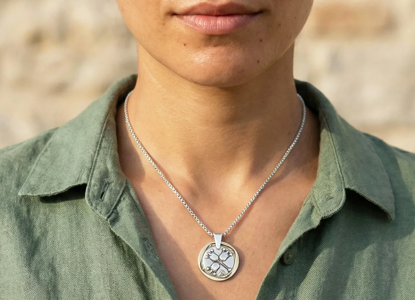 תליון ממטבע לירה רימונים ומטבע 10 אגורות מסביב